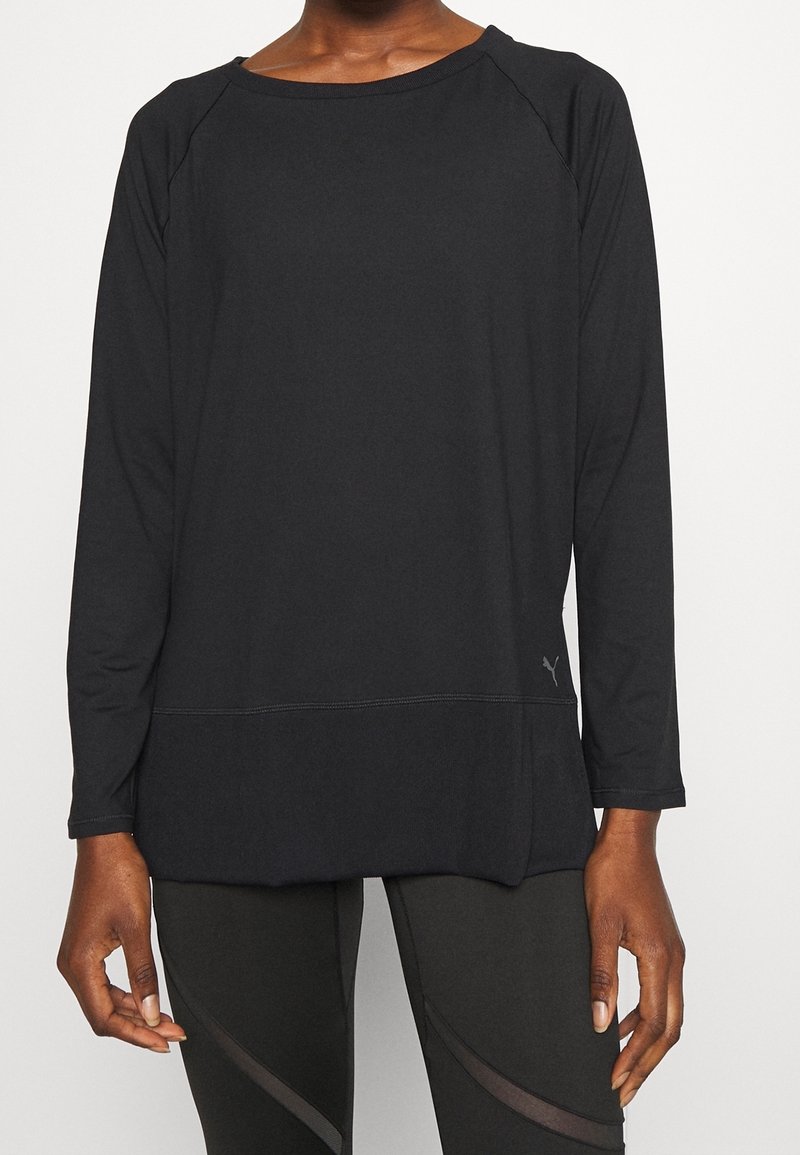 Czarna, długosleeve'owa koszulka sportowa z okrągłym dekoltem, rękawami raglanowymi i luźnym krojem, z dyskretnymi detalami w szwach.