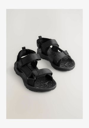 Čierne sandále s nastaviteľnými popruhmi, textúrovanou gumovou podrážkou s geometrickým vzorom a odolným syntetickým horným materiálom.