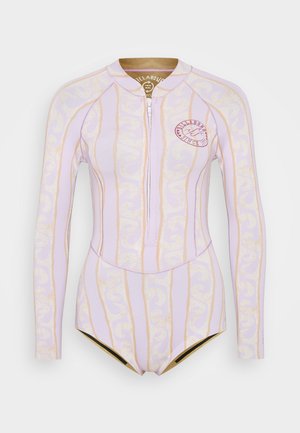 Long-sleeve rash guard in pale lavender with wavy gold and white patterns, featuring a front zipper and round logo patch. Smooth, stretchy material.