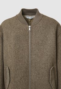 Giacca bomber in lana marrone con colletto a costine, zip argentata e tasche frontali inclinate. Tessuto strutturato e design su misura.