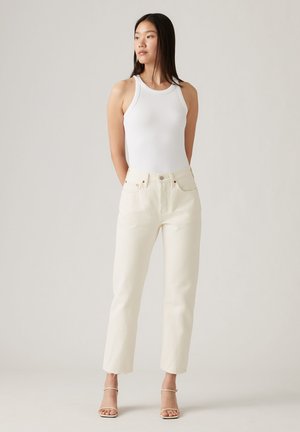 White ribbed tank top paired with off-white high-waisted straight-leg jeans, featuring frayed hem and minimal metal accents.