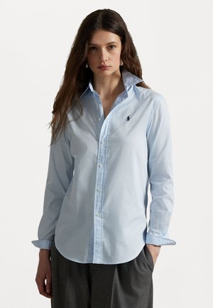 Light blue button-up shirt in cotton, featuring a classic collar and embroidered logo on the chest. Long sleeves with buttoned cuffs.