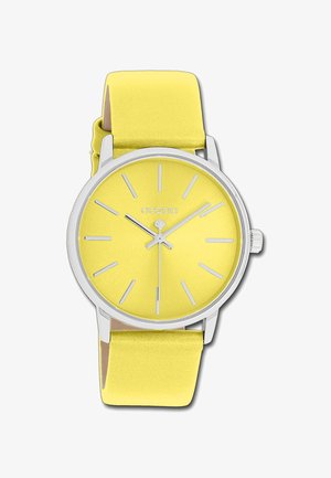 Montre ronde jaune avec une finition mate, marqueurs d'heures et aiguilles en argent. Bracelet en silicone jaune doux, quincaillerie en argent poli.