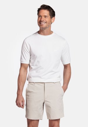 Witte katoenen T-shirt met korte mouwen, gecombineerd met lichtbeige shorts. De outfit heeft een ontspannen pasvorm en een eenvoudig ontwerp.
