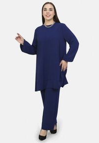 Navyblaue Zweiteiler-Set bestehend aus einer langen Tunika mit langen Ärmeln und geraden Hosen, aus weichem Stoff mit minimaler Struktur.