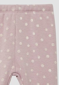 Leggings rose pâle en tissu doux avec une taille extensible, ornés de pois crème répartis sur toute la surface.