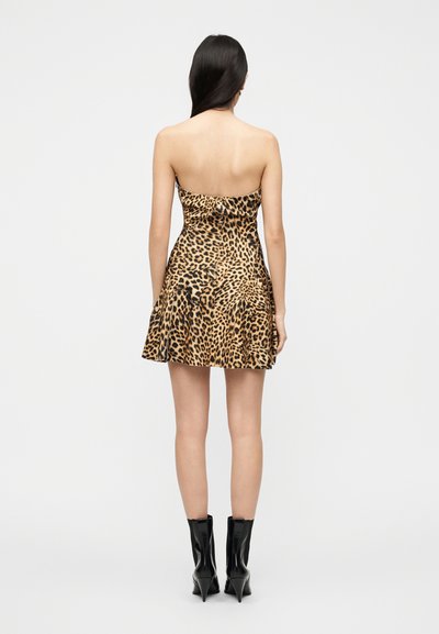 Μίνι φόρεμα με λεοπάρ σχέδιο, εφαρμοστό μπούστο, φούστα με βολάν και στυλ χωρίς τιράντες, σε συνδυασμό με μαύρες μυτερές μποτάκια μέχρι τον αστράγαλο.