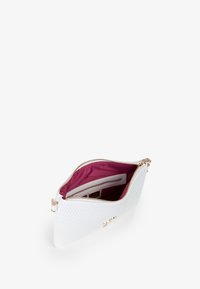 Borsa a tracolla bianca con texture e chiusura a zip. Interno foderato in tessuto bordeaux, presenta una tasca con zip e slot per carte. Finiture in oro.