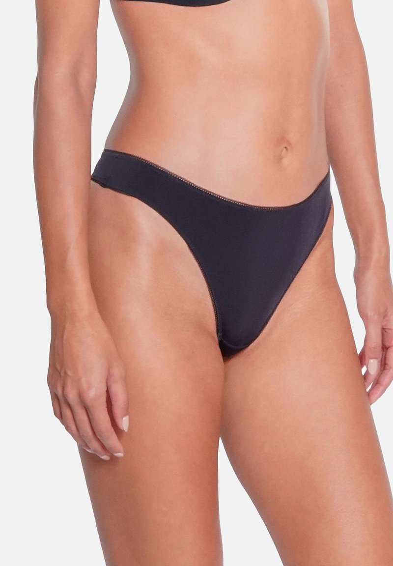Bas de bikini noir avec une couverture minimale, fabriqué en tissu lisse. Il présente un design simple et une ceinture élastique pour le confort.