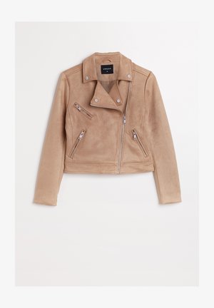 Veste de motocyclette en daim beige avec une coupe courte, fermeture éclair asymétrique, boutons-pression et plusieurs poches zippées. Texture douce.