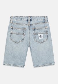 Světlé modré džínové kraťasy s rovný střih, obsahující dvě zadní kapsy a štítek s logem CK na pravé kapse. Detaily v měděném prošívání.