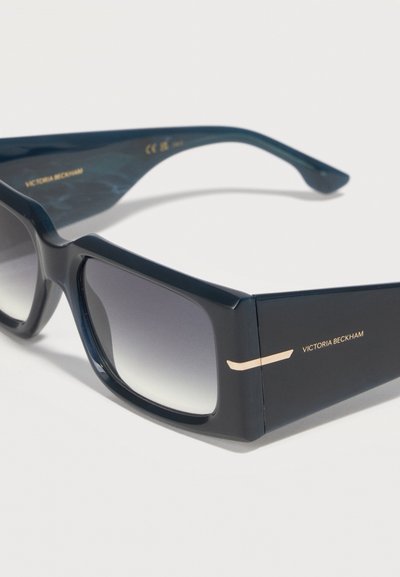 Ορθογώνια μαύρα γυαλιά ηλίου με σκούρους φακούς διαβάθμισης και χρυσό λογότυπο «Victoria Beckham» στον χοντρό βραχίονα του βραχίονα.