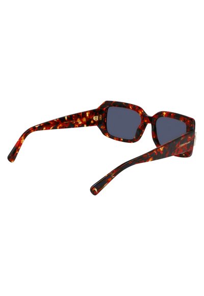 Lunettes de soleil en écaille de tortue avec des montures rectangulaires massives, des verres foncés et une finition brillante. Présente des motifs distinctifs rouges et bruns.