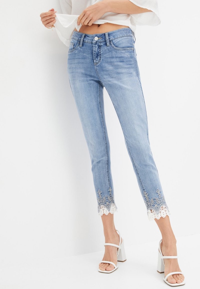 Svetle modré džíny z denimu s vydřeným povrchem, s kraječkou na lemu a výšivkovými detaily, s přiléhavým střihem.