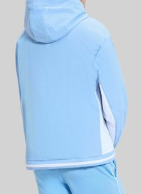 Jasnoniebieska kurtka z kapturem o gładkiej teksturze, z jednolitymi panelami kolorystycznymi, białą podszewką oraz sportowym krojem u dołu.