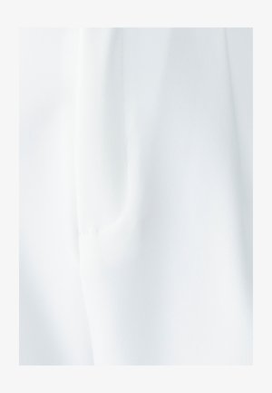 Tissu blanc à texture lisse ; présente une poche latérale et des détails de couture subtils, offrant un design épuré et minimaliste.