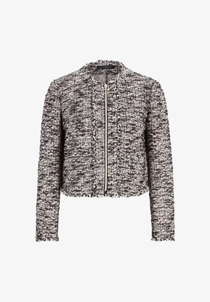 Svart och vit kort jacka i texturerad måln, med rund krage, fram zip-stängning och fransiga detaljer längs kanterna.