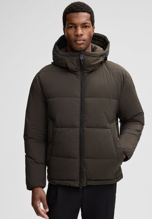 Dunkelgrüne Pufferjacke mit Kapuze, ausgestattet mit einem Frontreißverschluss und einem gesteppten Design. Glatte Textur, elastische Bündchen und seitliche Taschen.
