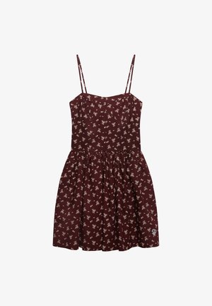 Robe fleurie bordeaux avec fines bretelles, corsage ajusté et jupe évasée. Présente un petit motif de fleurs blanches et un logo décoratif sur l'ourlet.