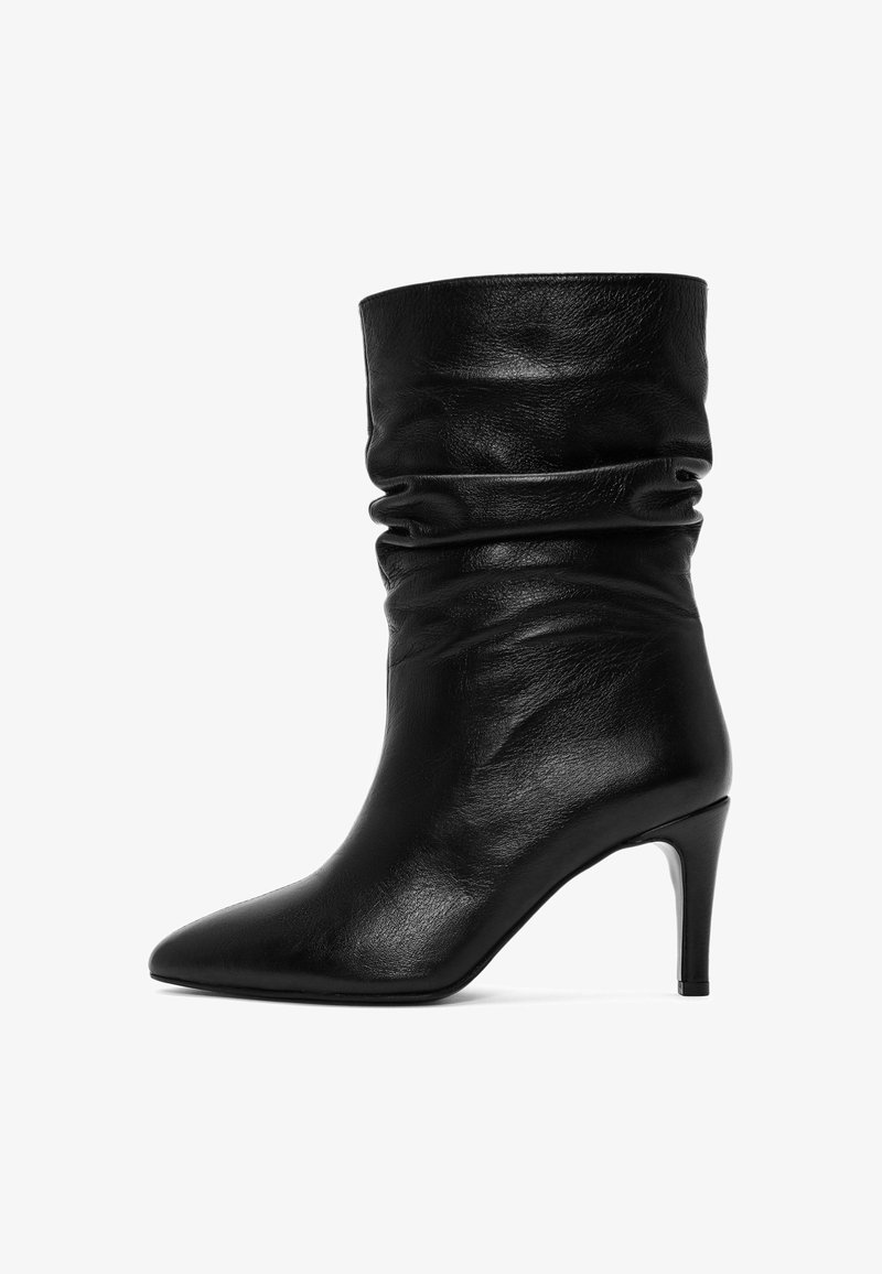 Czarne skórzane botki sięgające kostki o luźnym kroju, z szpiczastym noskiem i cienkim obcasem. Gładka faktura i minimalna ilość detali metalowych.