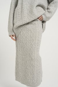 Pull en maille grise et jupe assortie, avec un motif de câble texturé, des poignets côtelés et une coupe décontractée et confortable. Matière douce en mélange de laine.