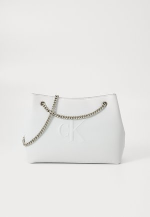 Sac à main rectangulaire blanc avec anse chaîne argentée et logo "cK" en relief sur surface lisse sur fond uni.