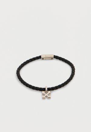 Bracelet en cuir noir tressé avec fermoir magnétique argenté et petit pendentif carré en argent présentant un motif géométrique gravé.