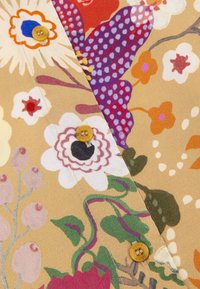 Stof met bloempatroon in beige tinten met kleurrijke bloemen en bladeren, voorzien van gele knopen en een gladde textuur.