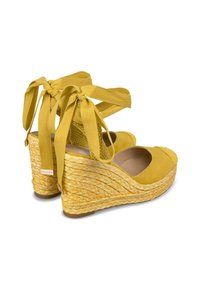 Sandali gialli con tacco a wedge, superiore in suede, piattaforma in juta intrecciata e lacci in raso intorno alla caviglia. Punta rotonda e tacco testurizzato.