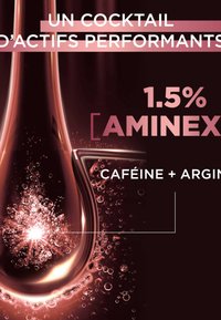 Flacon compte-gouttes teinté de rose avec des bulles, étiqueté "1,5 % AMINEX, CAFÉINE + ARGININE" sur un fond bordeaux profond.