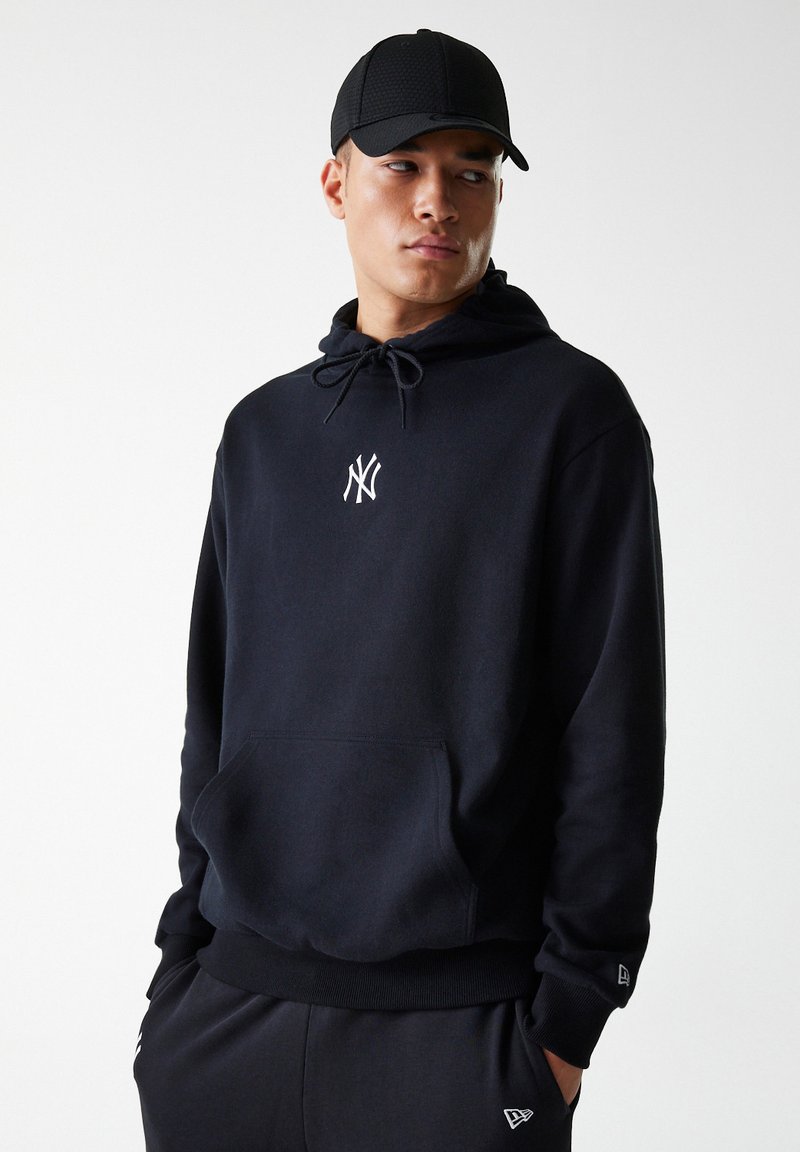 Sudadera con capucha negra, con un bolsillo frontal, material de algodón ligero, cordones ajustables y un pequeño logo blanco en el pecho.