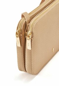 Beżowa torba syntetyczna z podwójnymi komorami na zamek, teksturowana powierzchnia z wzorem w jodełkę oraz złotymi akcentami sprzętu.