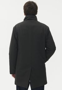 Črna jakna z visokim ovratnikom, gladko teksturo in ravnim krojem, z razporkom na hrbtni strani in dolgimi rokavi.