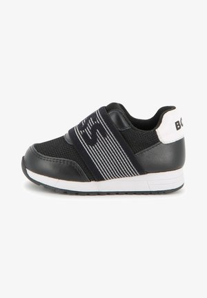 Crna sportska cipela s mrežastim gornjim dijelom, gumenim potplatom i elastičnom trakom sa prugastim uzorkom. Ima bijele detalje na peti.