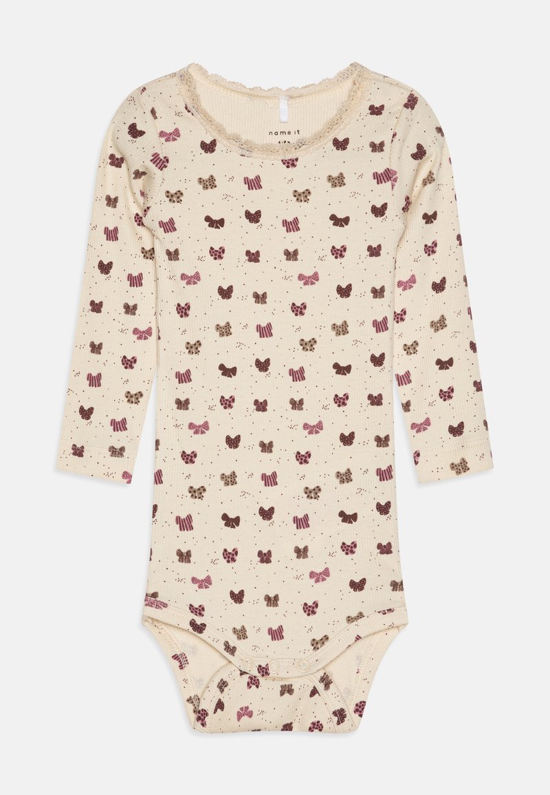 Pitkähihaisen vauvan body vaaleassa sävyssä, jossa on ruskean ja vaaleanpunaisen rusetin tekstuurimallia. Varustettu neppareilla alaosassa helppoa vaihtoamista varten.