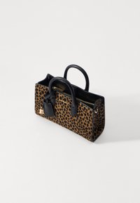 Leopard print handbag with black leather accents, top handles, zip closure, and a detachable luggage tag. Textured fur exterior.