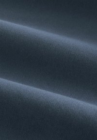 Tissu gris foncé lisse avec une texture subtile et des plis doux créant des ombres et des reflets délicats.