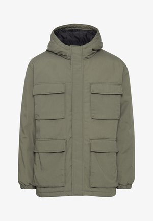 Maslinasto zelena jakna s kapuljačom, izrađena od sintetičkog materijala s podstavom od jastučića. Ima četiri prednja džepa i elastične manžetne.