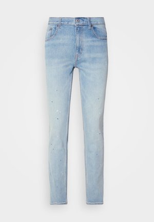 Light blue denim jeans with a slim fit, featuring paint splatter details and a classic five-pocket design. Button and zipper closure.