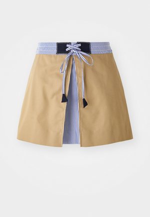 Krémová sukně s modrým pruhovaným pasem, s krajkovým předním zapínáním a černými akcenty. Hladký materiál, střední délka s přizpůsobeným střihem.