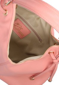 Borsa a tracolla in pelle rosa con una superficie testurizzata. L'interno presenta una fodera beige e una tasca con cerniera con etichetta "Made in Italy".