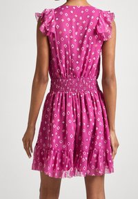 Fuksjowa sukienka z falbankami na rękawach, marszczonym pasem i warstwową spódnicą. Charakteryzuje się geometrycznym nadrukiem w jaśniejszych odcieniach na teksturowanej tkaninie.