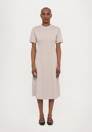 Light gray short-sleeve dress with a round neckline, A-line silhouette, and center seam detail, paired with dark brown strap shoes.