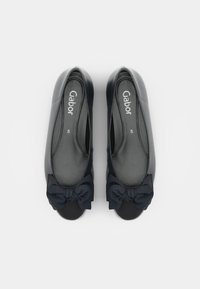 Ballerines en cuir noir au toucher lisse, à bout rond et avec un nœud noir proéminent à l'avant. Logo Gabor visible à l'intérieur.
