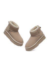 Beige Kurzstiefel aus weichem Wildleder mit flauschiger Fütterung, runder Zehenform und flacher Gummisohle, akzentuiert durch minimalistische Nähte.