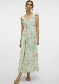 Abito maxi in verde chiaro con motivi floreali rosa e arancione. Presenta spalline a volant e un corpetto aderente. Tessuto leggero con una forma fluida.