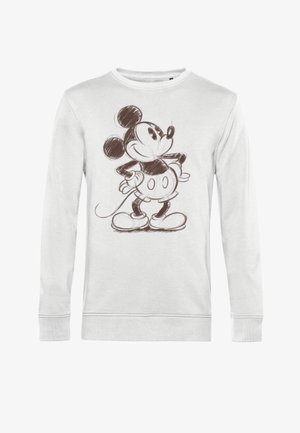 Witte sweatshirt met lange mouwen met een bruine schets van een cartoon muis met grote oren, handen op de heupen en zwarte schoenen.