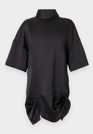 Haut noir en satin à manches courtes avec col montant et détail d'ourlet drapé froncé sur un fond clair uni.