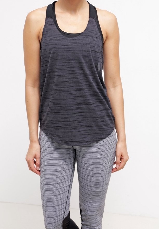 Zwart en grijs gestreept sporttanktop met een afgeronde zoom, gecombineerd met grijze leggings met horizontale strepen en zwarte accenten.