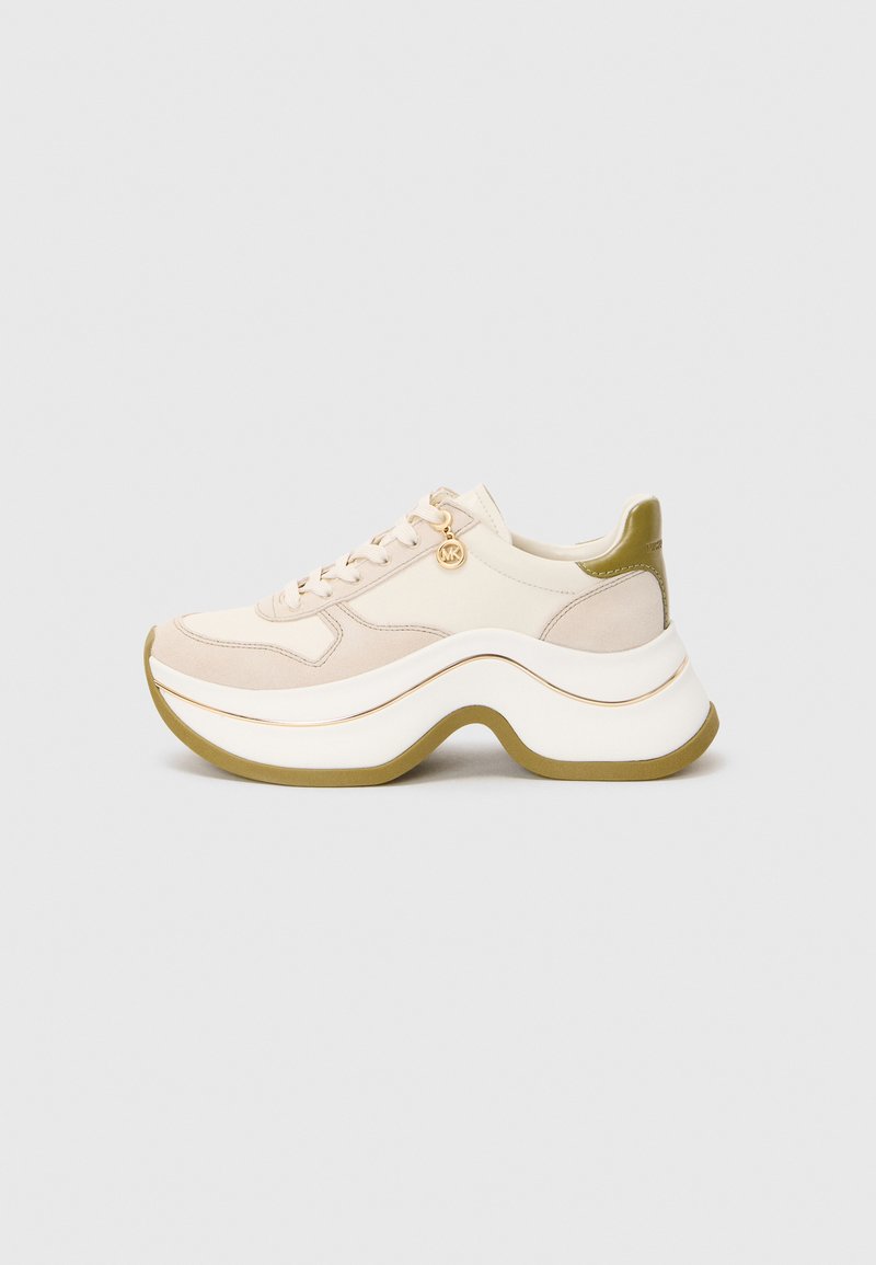 Beige en witte chunky sneaker met golvende dikke zool, olijfgroene accenten, veters en een klein gouden merksieraad aan de zijkant, tegen een effen grijze achtergrond.